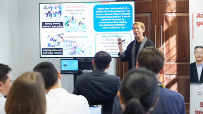 A conference delegate presenting a slide to other conference delegates.