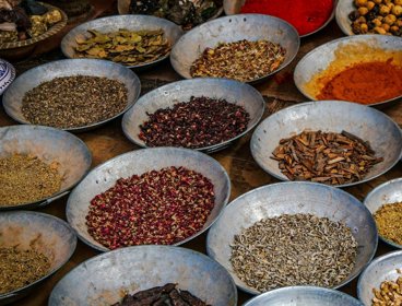 Bowls of spice on a wooden table.
