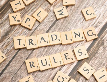 Scrabble pieces that spell out 'trading rules'.