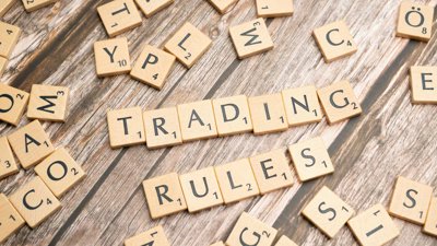 Scrabble pieces that spell out 'trading rules'.