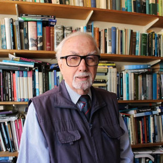 David Jones standing in front of bookshelves