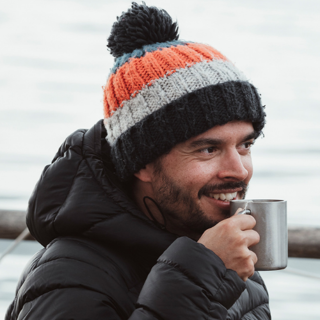 Tom Napper drinking from mug and wearing wooly hat.