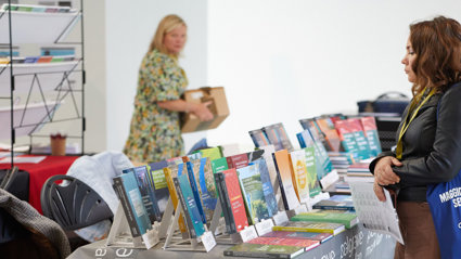 A person browsing a table of books.