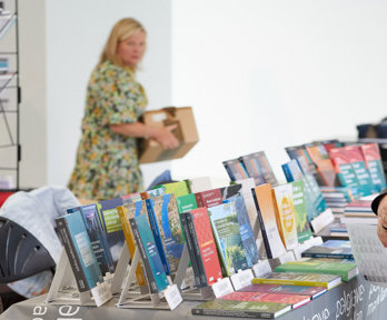 A person browsing a table of books.