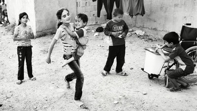 Five children on a street in Lebanon. One child carries a younger one.