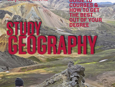 People walking across a rocky ridge with mountains in the background