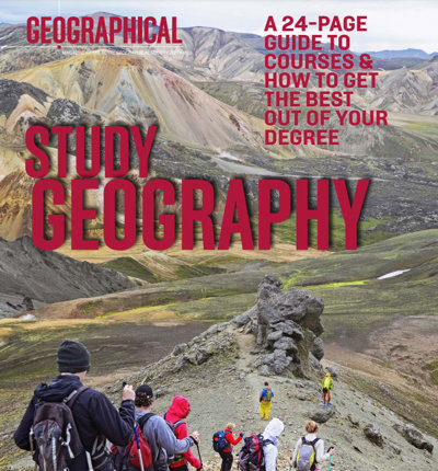 People walking across a rocky ridge with mountains in the background