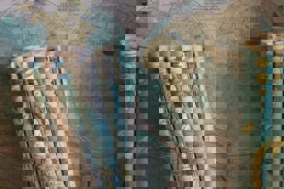 Map scrolls leaning up against a backdrop of another map