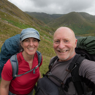 Rob and Harriet Fraser with backpacking gear taking a selfie in the mountains.