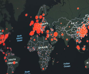 Red circles depicting data on a digital world map. 