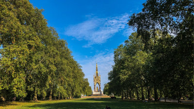 Hyde Park with two lines of large trees and the Albert Memorial in the centre.