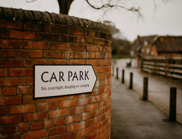 A car park sign on a brick wall.