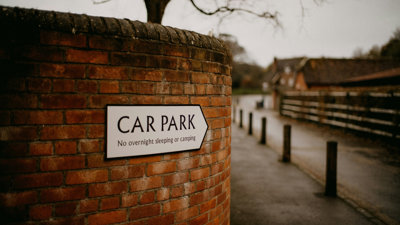 A car park sign on a brick wall.