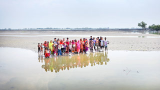 A large, mixed group of people in a saline area.