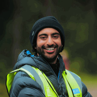 Samad Shahab wearing a hat and a yellow, reflective vest.