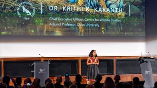 Dr Krithi Karanth on stage giving a lecture.