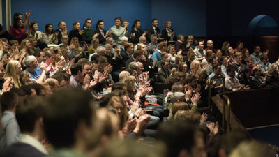 Audience in a theatre clapping.