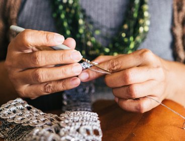 Person holding a crochet hook and crocheting. 