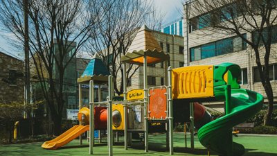 Children's play area in front of a building during daytime.