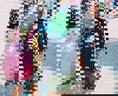 children cross the road in pairs whilst holding hands. 