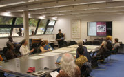 A group of people sit around a table and look at maps.