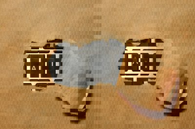 A computer keyboard covered with brown wrapping paper. The paper is ripped with the letters A I showing