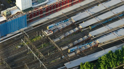 Aerial view of a train station, with trains stationary at the platforms.