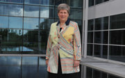 A woman wearing a coat with a map printed on it standing in front of a modern building.