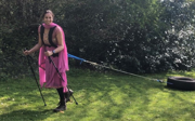 Preet Chandi in Indian suit dragging tyre in green garden.