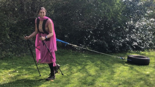 Preet Chandi in Indian suit dragging tyre in green garden.