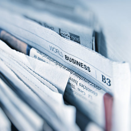 A selection of bunched up newspapers, the prominent one reads 'World Business'