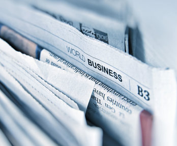 A selection of bunched up newspapers, the prominent one reads 'World Business'