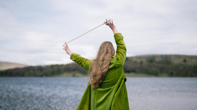 Sarah standing with her back to the camera, holding a cello bow in her hand