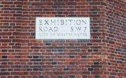 The exhibition road street sign on the brick wall of the Royal Geographical Society.
