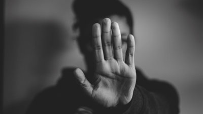 A person holding their hand in front of their face.
