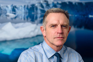 Portrait of David Vaughan wearing a blue shirt
