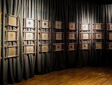 Suzhou embroidery displayed on black curtain wall. 