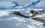 A wide, barren, mountainous landscape covered in snow.
