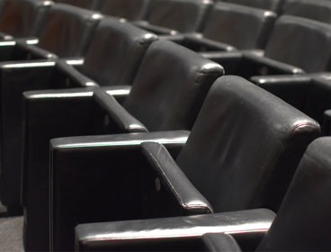 A row of leather chairs in a lecture theatre.