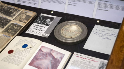 Display of historic materials, including a film reel, books, and advertisements.