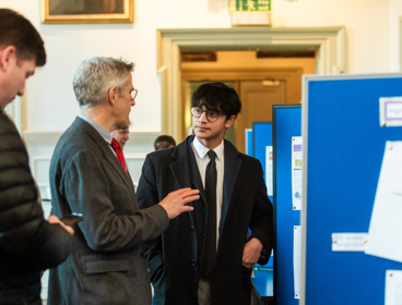 Two people talking to each other at a conference.