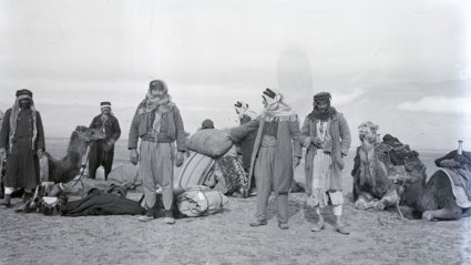 Black and white photohraph of travellers in a desert by Gertrude Bell.