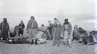 Black and white photohraph of travellers in a desert by Gertrude Bell.