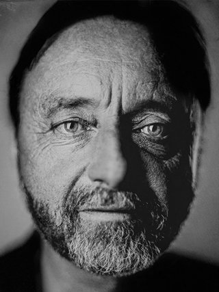 Headshot photograph of Frans Lanting in black and white.