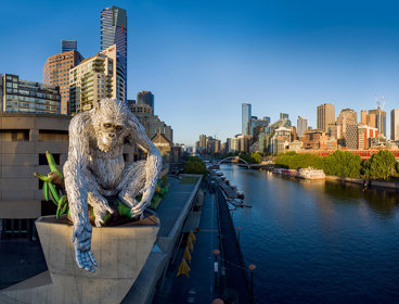 Ape structure on top of building next to city skyline.