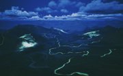Dark mountainous landscape with rivers of blue and green.