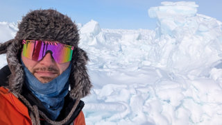 Robbie Mallett taking a self in the snow, wearing a hat and glasses