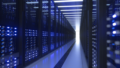 A room holding rows of data servers. Element of the room such as the white floor glow blue as a result of blue reflected light being emitted by the servers.