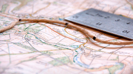 Map, ruler and string close-up.