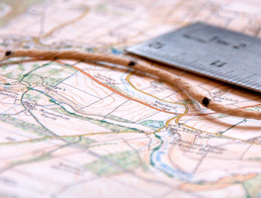 Map, ruler and string close-up.